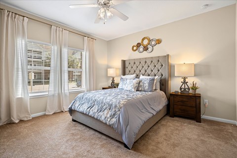 A bedroom with a large bed and a ceiling fan.