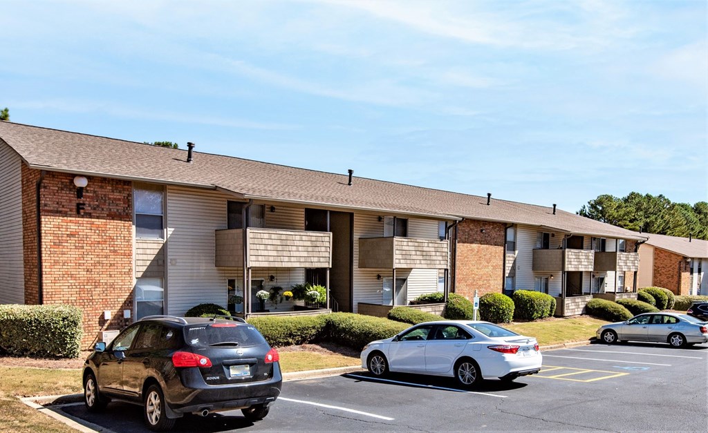 an apartment building with cars parked in a parking lot