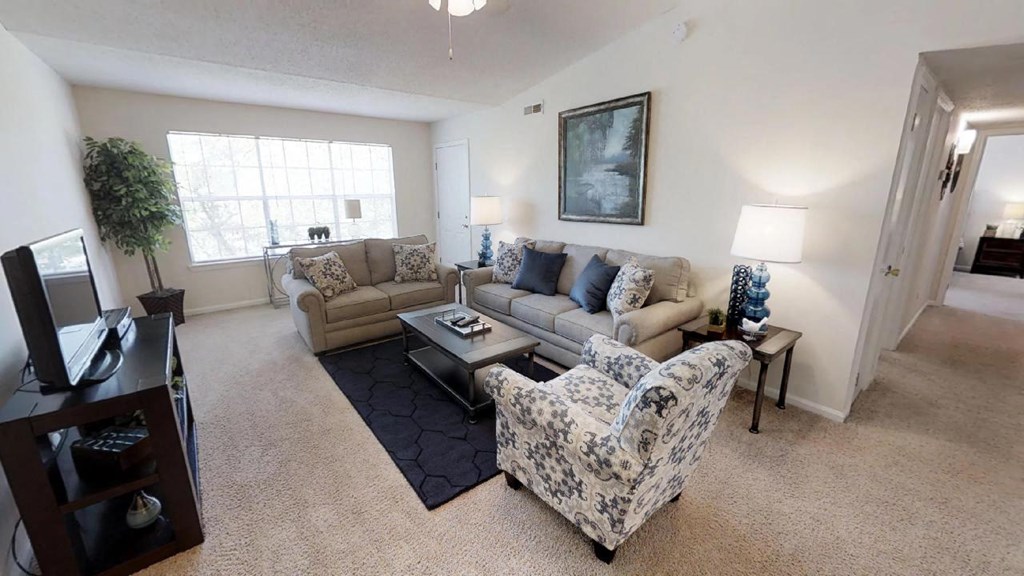 a living room with a couch and chairs and a tv