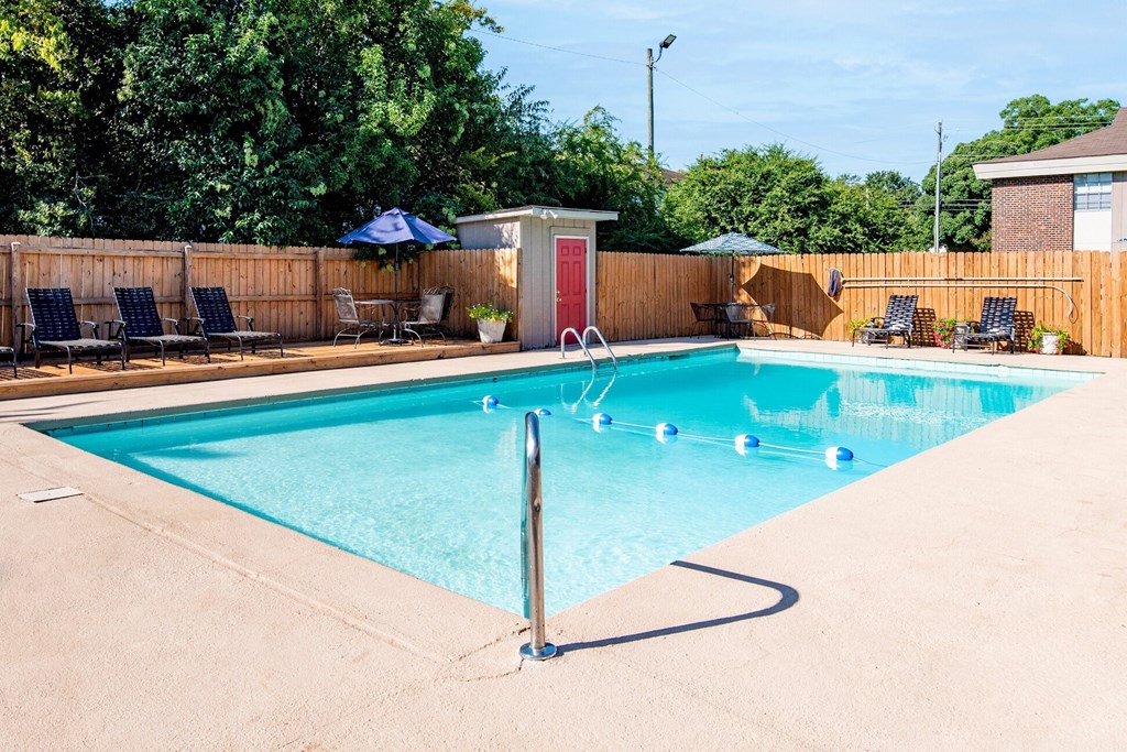 a swimming pool with a fence and chairs around it