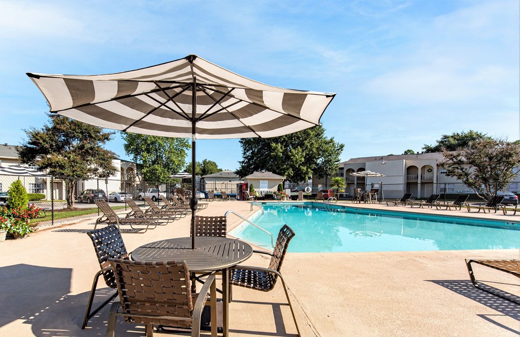 our apartments have a swimming pool and table with an umbrella