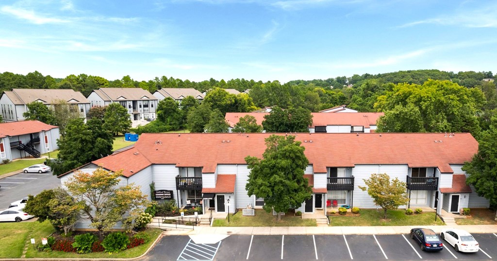 A parking lot in front of a building with a red roof.