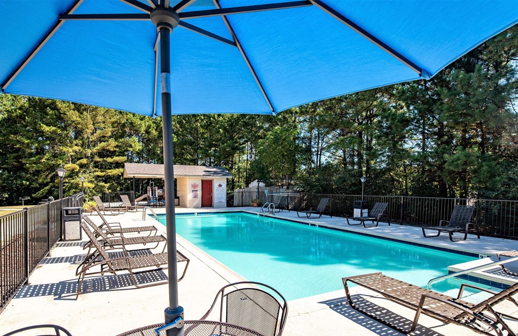 our resort style swimming pool is under a large blue umbrella