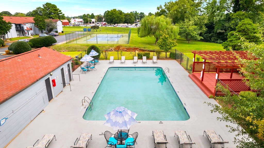 A large swimming pool surrounded by lounge chairs and umbrellas.