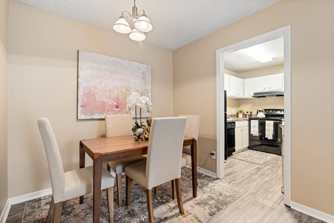 A dining room with a wooden table and chairs.
