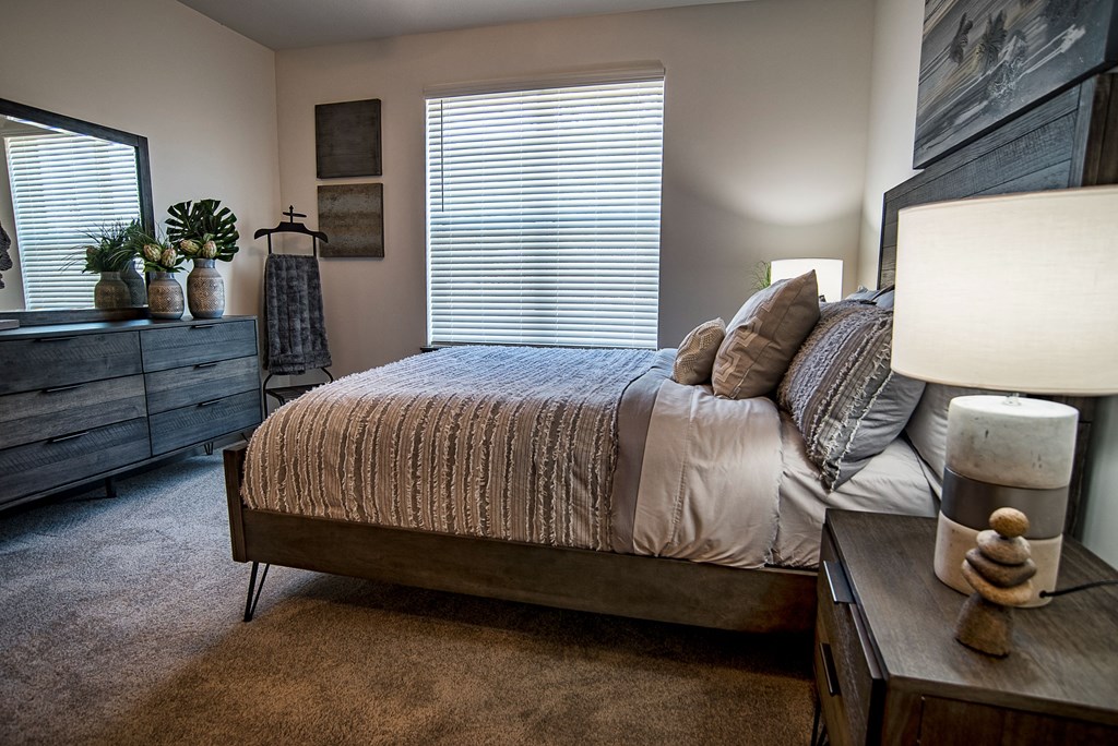 a bedroom with a bed and a dresser and a window