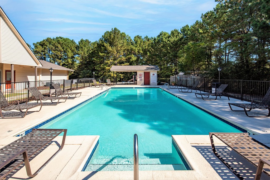 the swimming pool at our apartments with a pool house and chairs