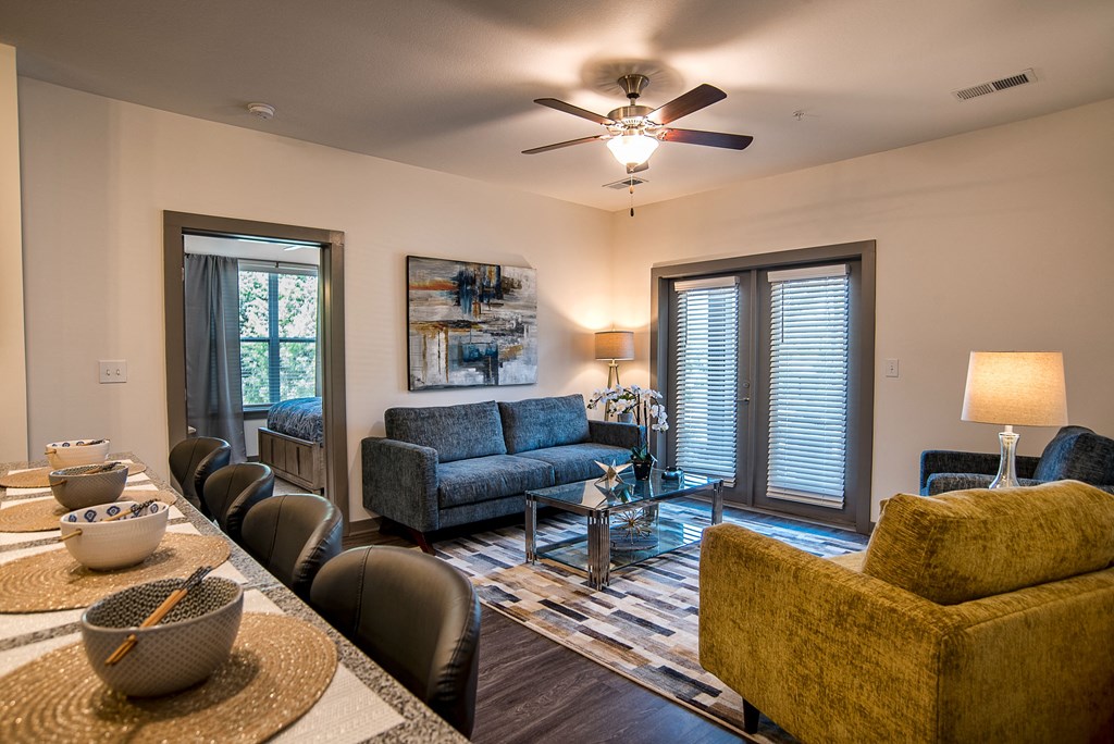 a living room with a couch and a table and a ceiling fan