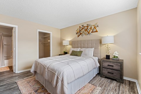 A bedroom with a large bed and a wooden dresser.