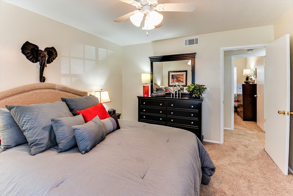 a bedroom with a large bed and a ceiling fan