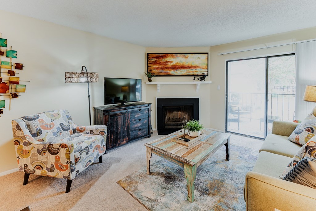 a living room with a fireplace and a sliding glass door