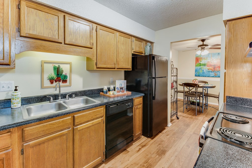 a kitchen with wooden cabinets and black appliances