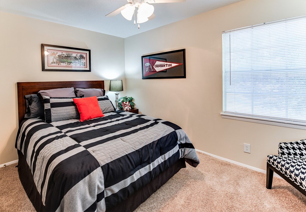 the bedroom has a large window and a black and white bed