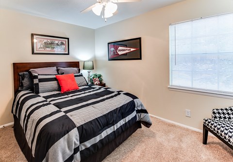 the bedroom has a large window and a black and white bed