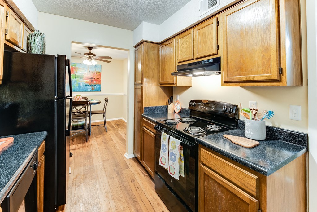 a kitchen with wood cabinets and black appliances