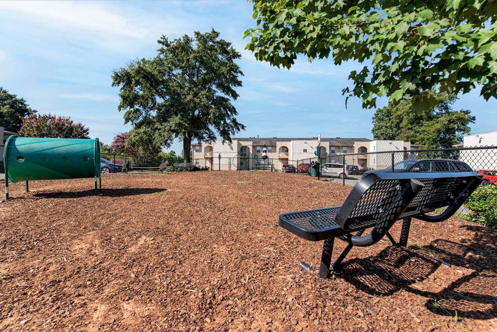 a park bench sits in front of a playground