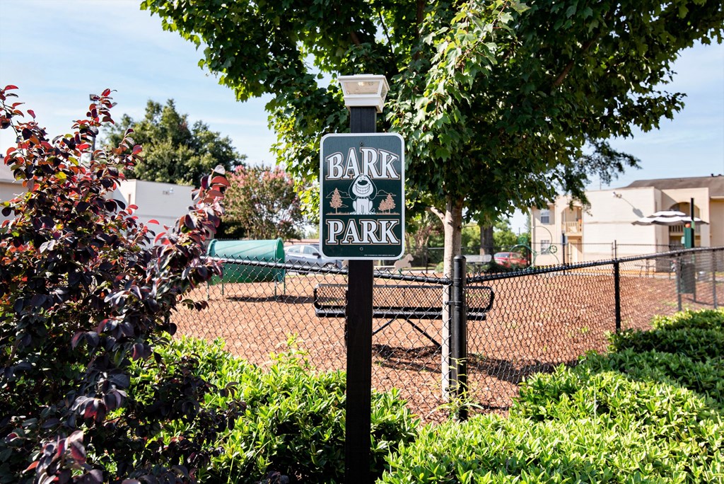 a bark park sign in front of a tennis court