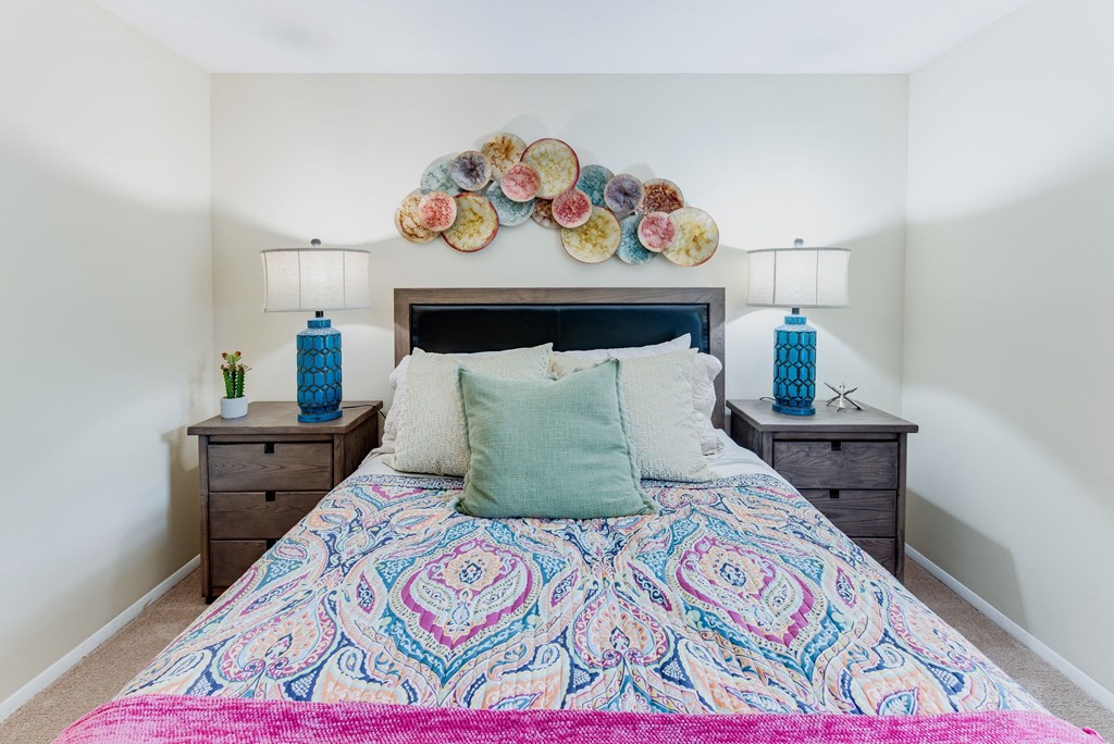 a bedroom with a large bed and two night stands with lamps