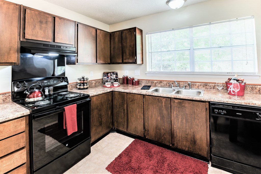 full kitchen with black appliances and granite counter tops with a window