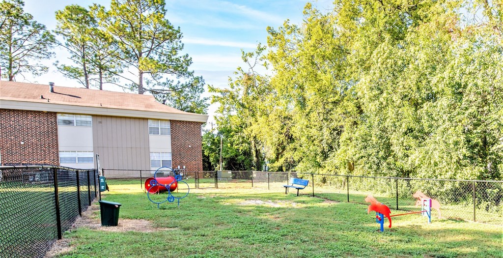 two children playing in a fenced in dog park