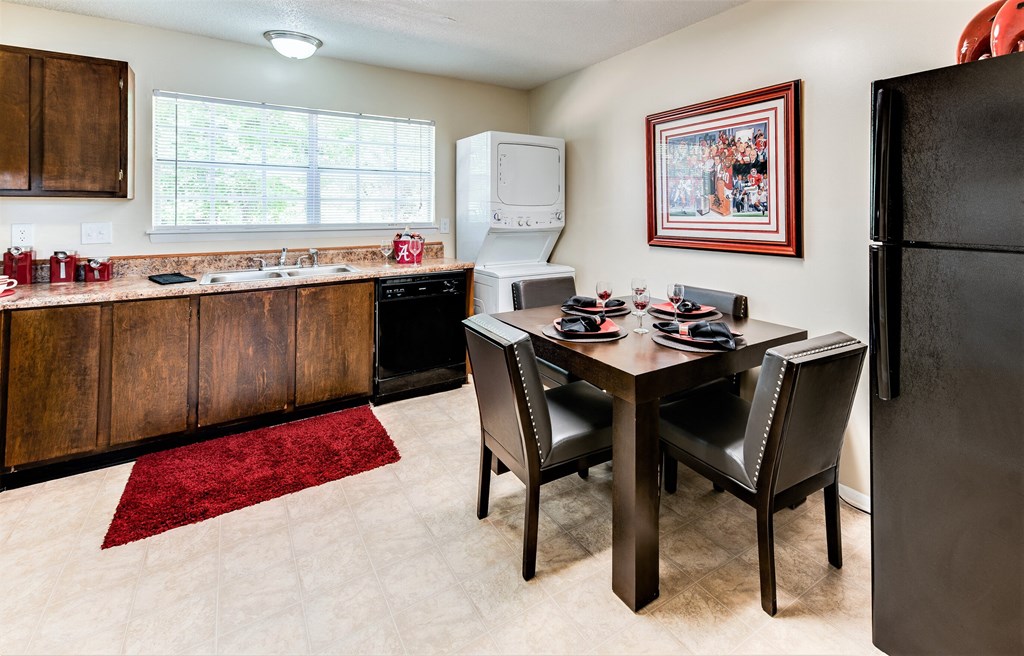 a kitchen and dining room with a table and chairs and a refrigerator