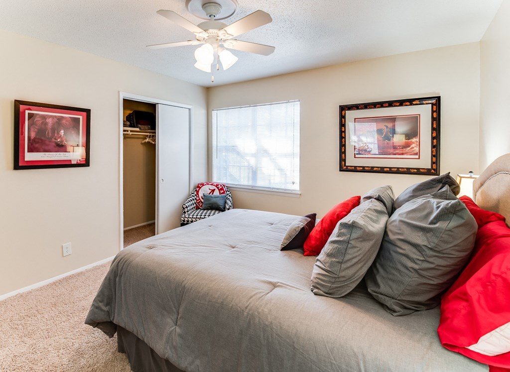 the master bedroom has a large bed and a ceiling fan