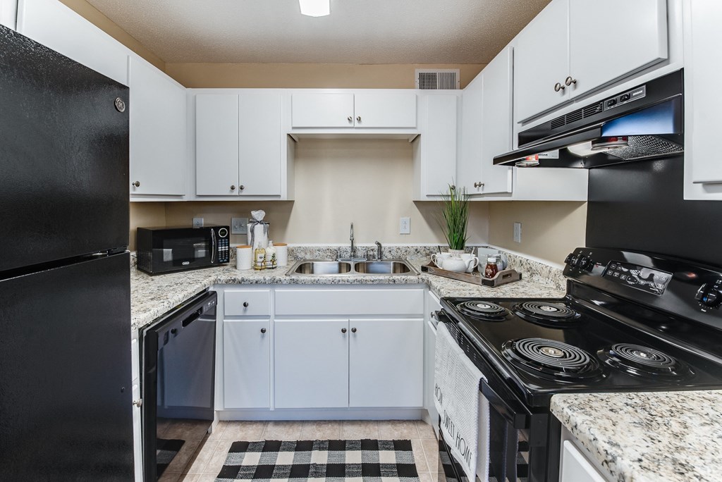 a kitchen with white cabinets and a black stove and refrigerator