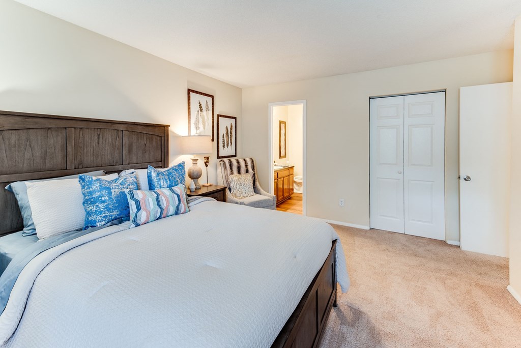 a bedroom with a large bed and a door to a bathroom