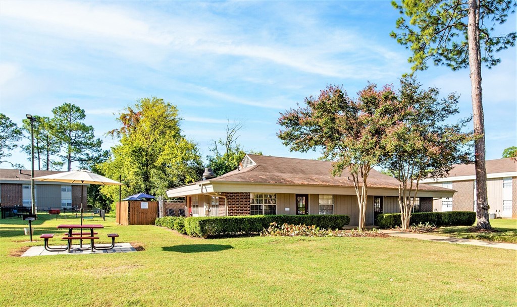 a yard with a picnic table in front of a house