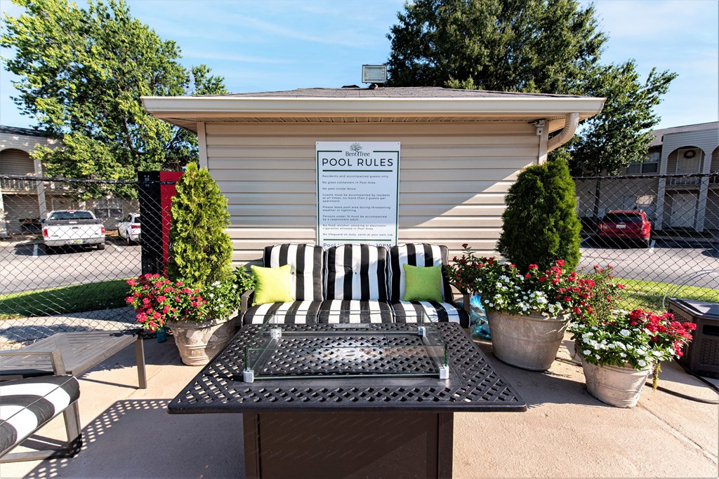 a patio with a table and chairs and a pool rules kiosk