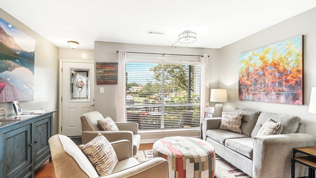 A living room with a grey couch, a chair, and a table.