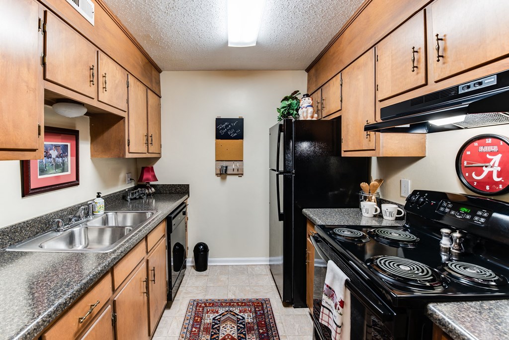 full kitchen with black appliances and granite counter tops and wood cabinets