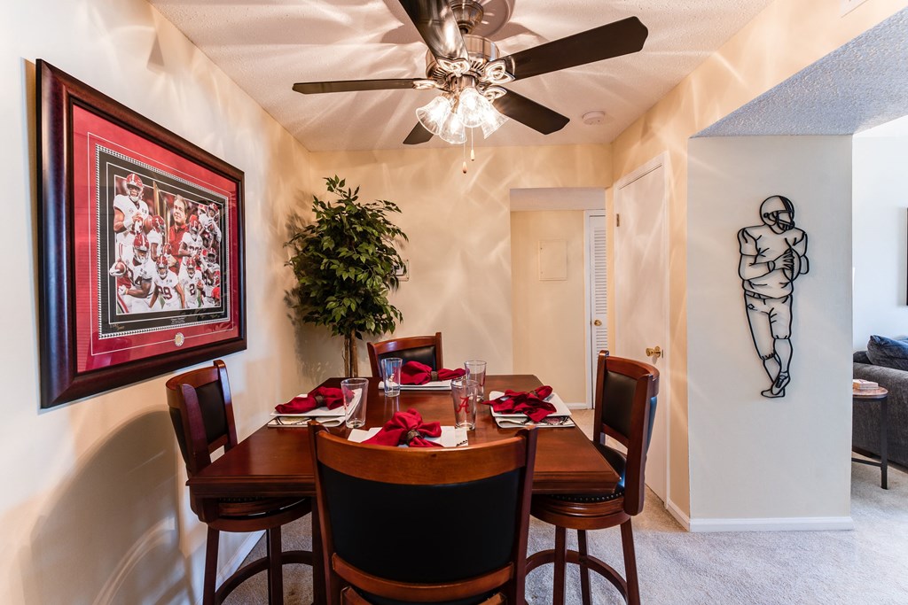a dining room with a table and chairs and a ceiling fan