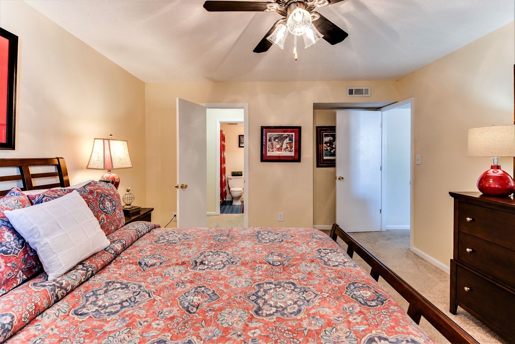 a bedroom with a large bed and a ceiling fan