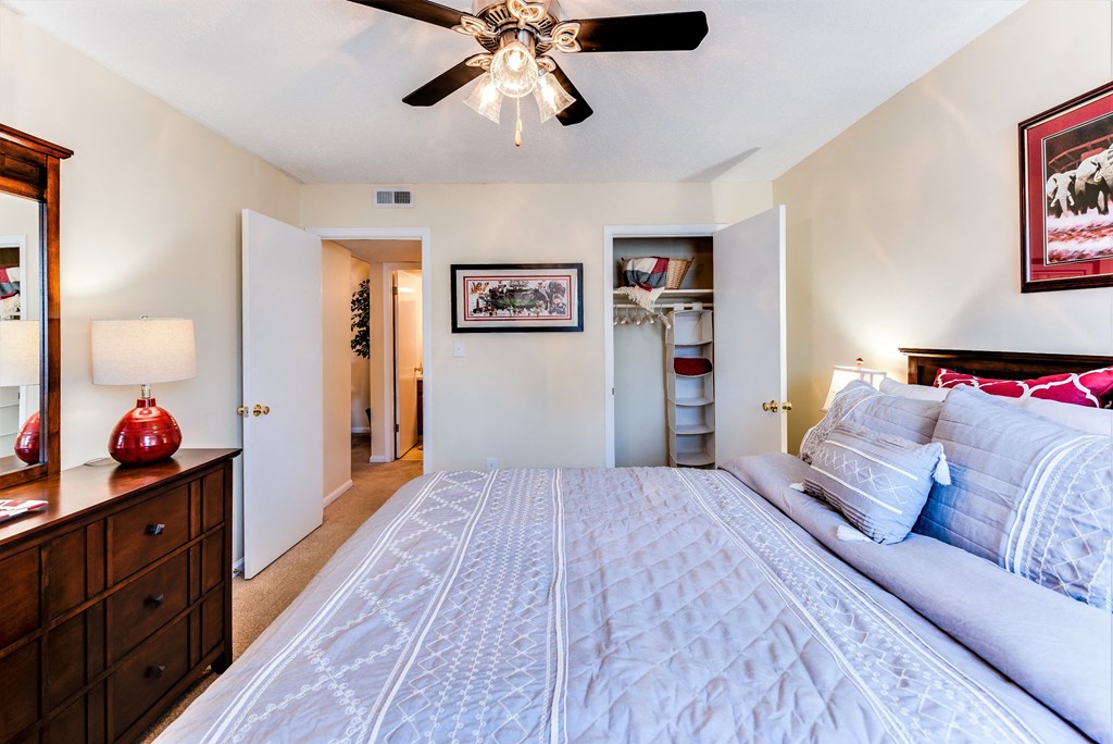 the master bedroom has a large bed and a ceiling fan