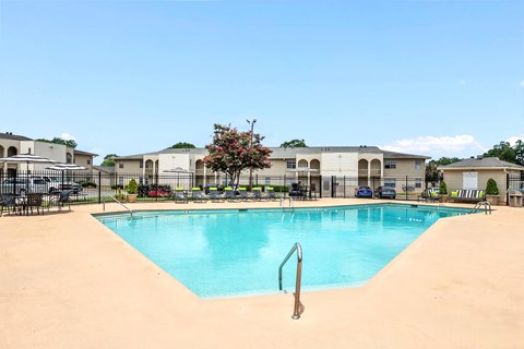 A swimming pool in a residential area with a sandy bottom.