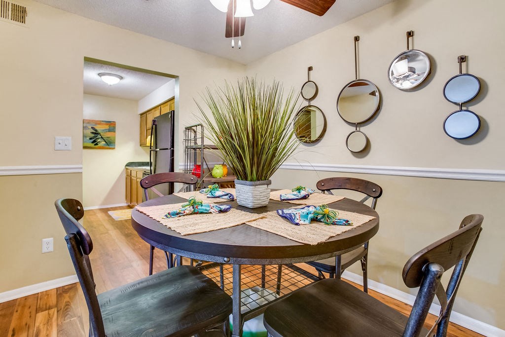 a dining room with a table and chairs      and a kitchen