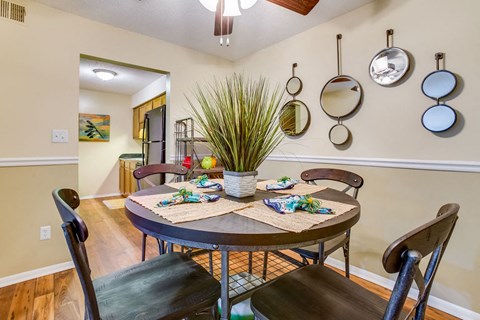 a dining room with a table and chairs      and a kitchen