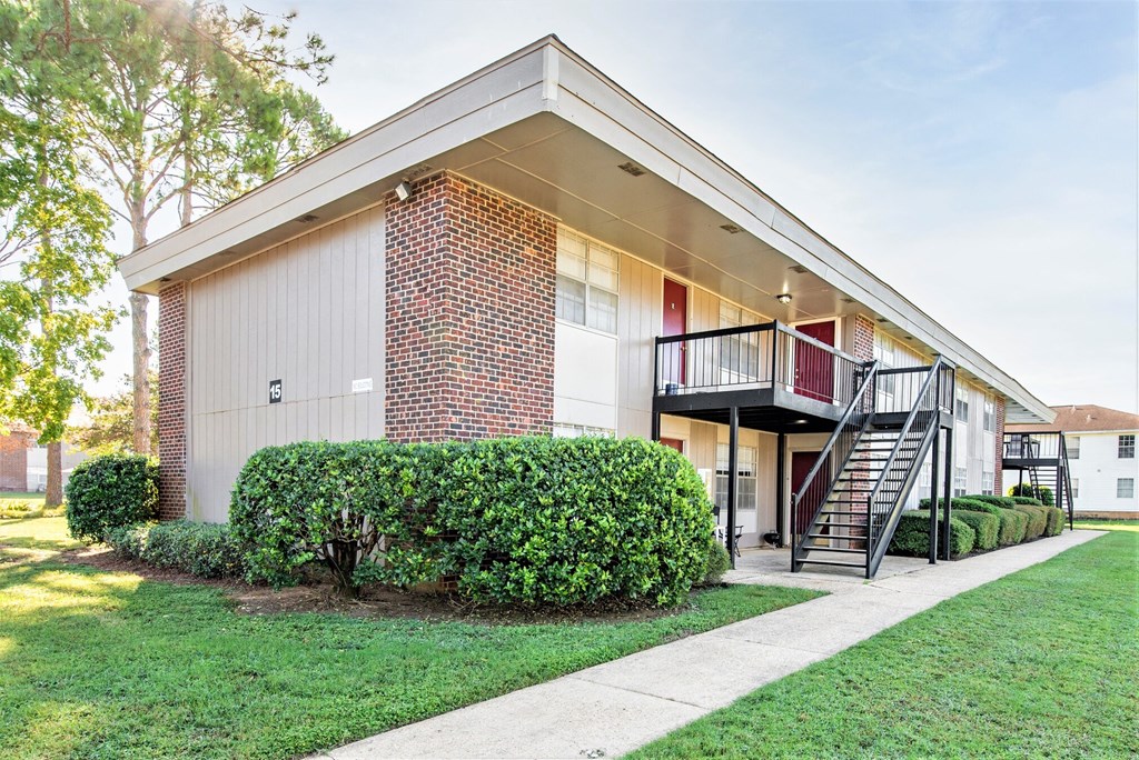 the front of a house with a yard and a staircase