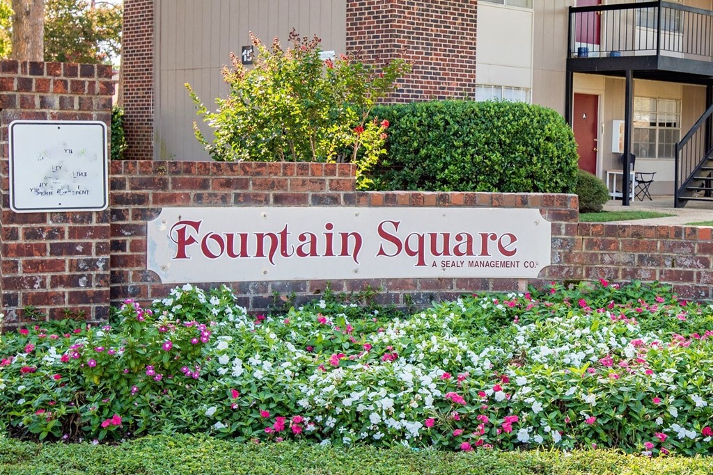 a brick wall with a fountain square sign in front of a building