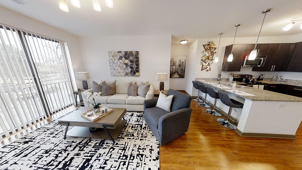 a living room with a couch and a kitchen with a bar