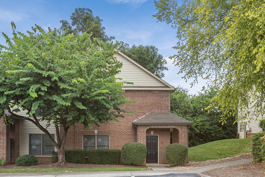 a brick house with a tree in front of it