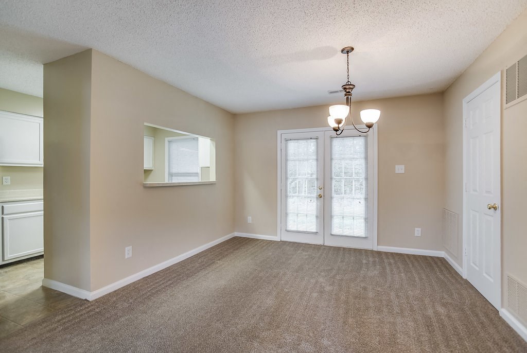 an empty living room with a door and a window