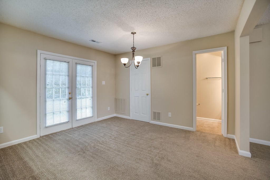 an empty living room with a door to a closet