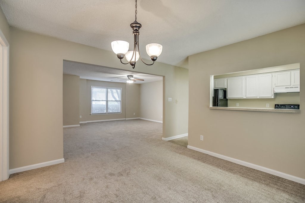 an empty living room and kitchen with a large window