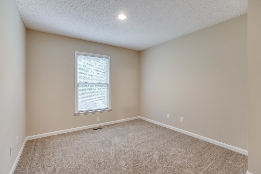 an empty room with carpet and a window