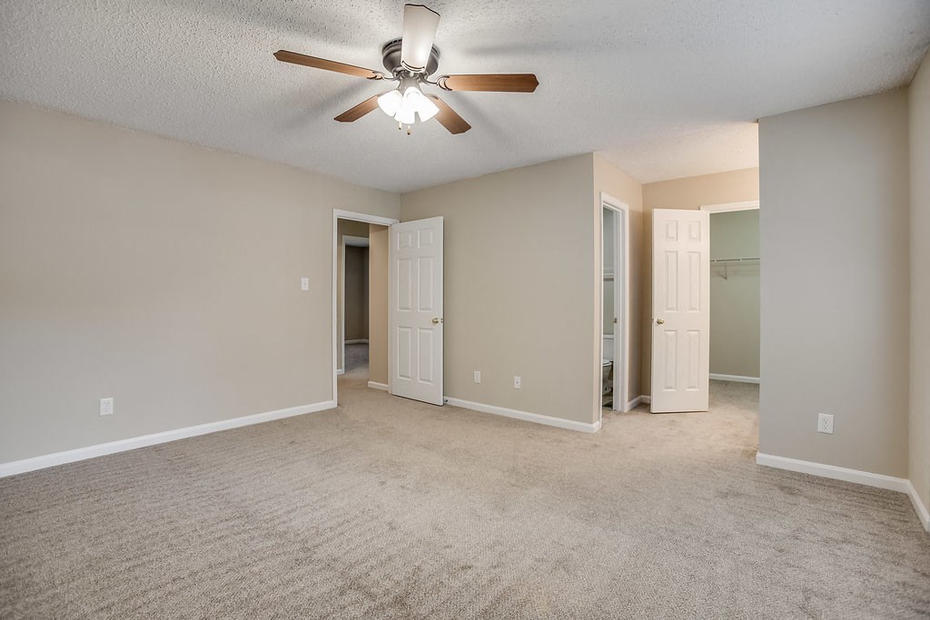 an empty living room with a ceiling fan