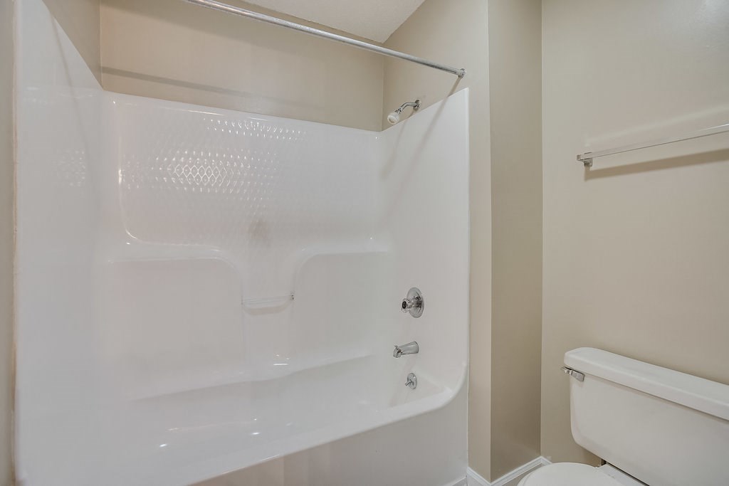 a white bathroom with a shower and a toilet