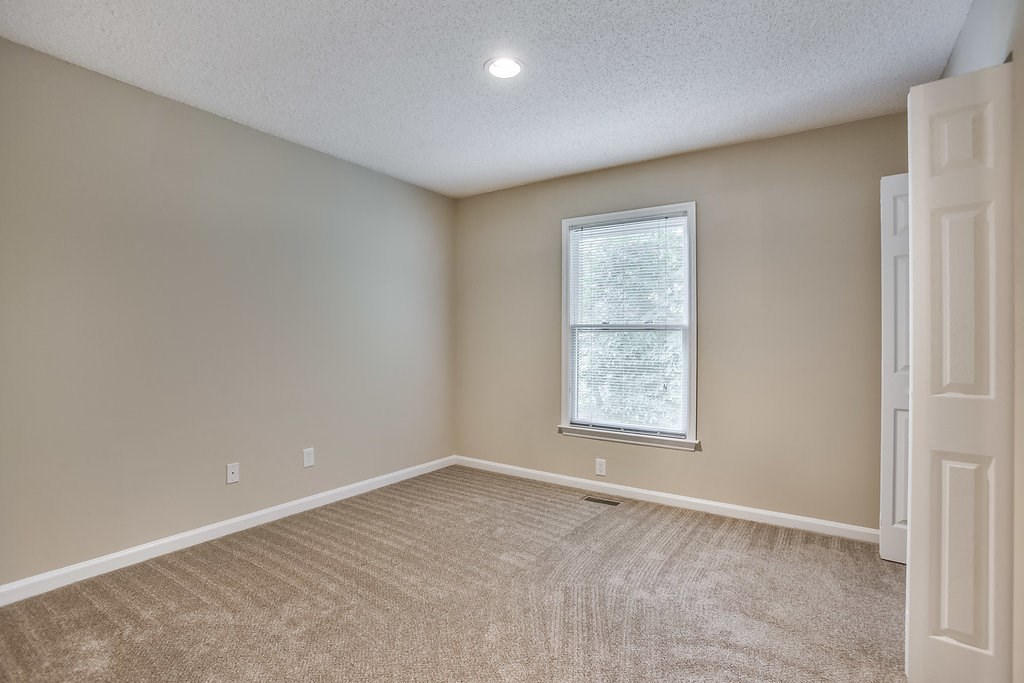 an empty room with carpet and a window