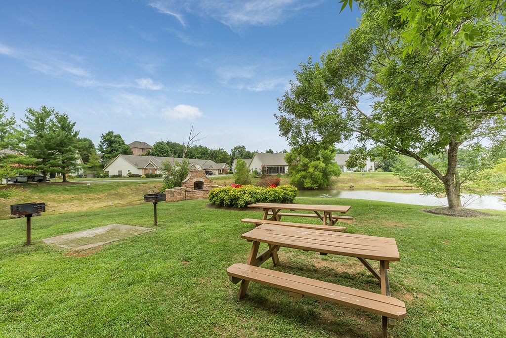 a group of picnic tables in a park next to a pond